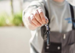 Mann hält Autoschlüssel in die Kamera